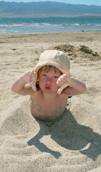 Малышка играет с песком — стоковое фото