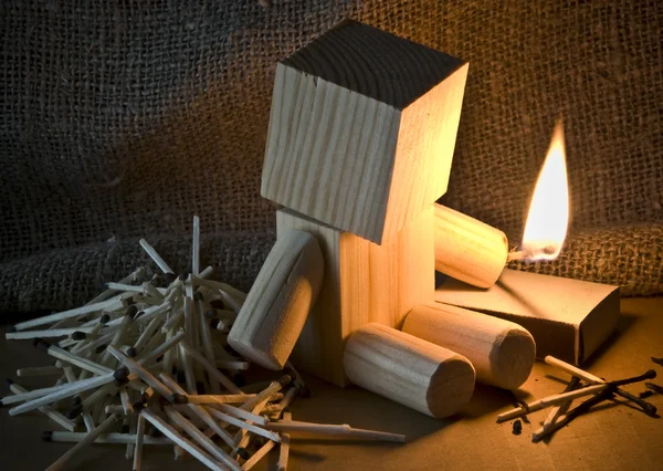 Een houten robot is spelen met vuur — Stockfoto