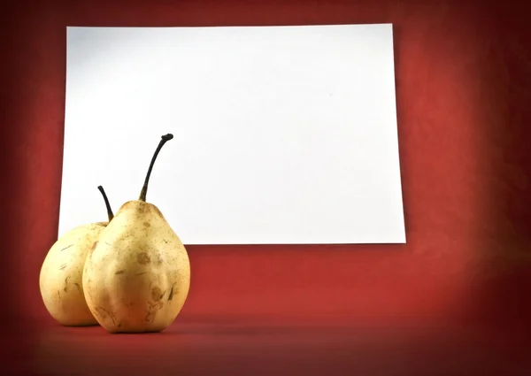 stock image Two ripe pears on a red background