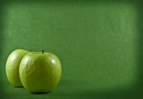 Twee rijpe appels op een groene achtergrond — Stockfoto