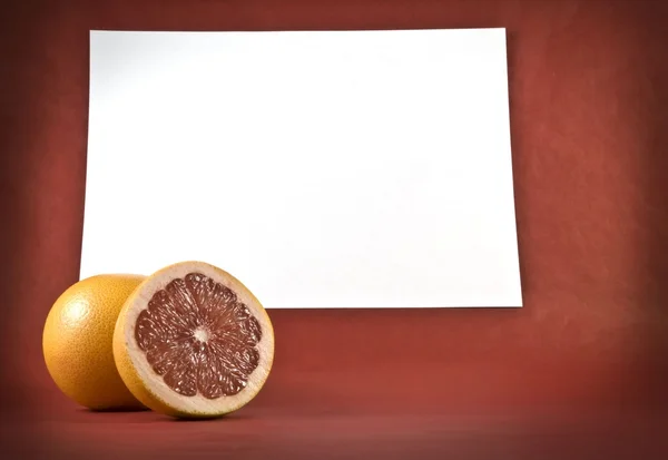 Twee grapefruits op een rode achtergrond — Stockfoto