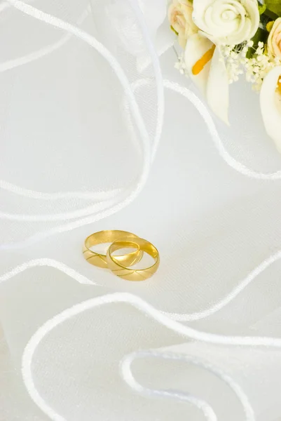 Anéis de casamento e flores sobre o véu — Fotografia de Stock