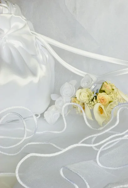 Fleurs de mariage et sac de mariée sur le voile — Photo