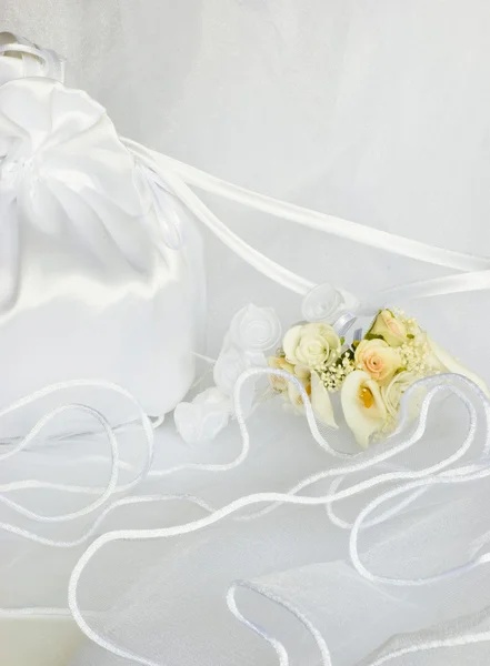 Свадебные цветы и свадебная сумка поверх вуали — стоковое фото