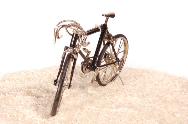 Spielzeugfahrrad auf weißem Reis — Stockfoto