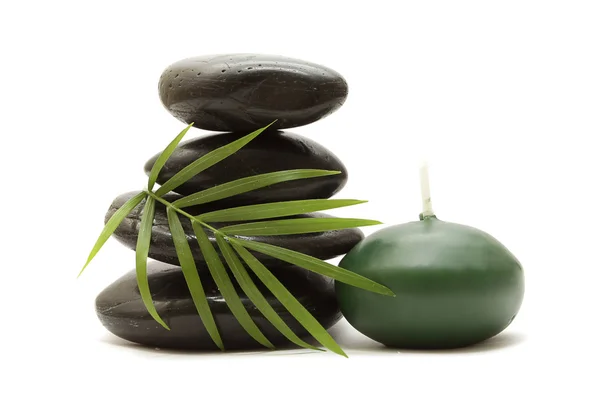 Pedras, folhas verdes e uma vela — Fotografia de Stock