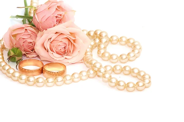 Zwei goldene Ringe, Perlen und Blumen — Stockfoto