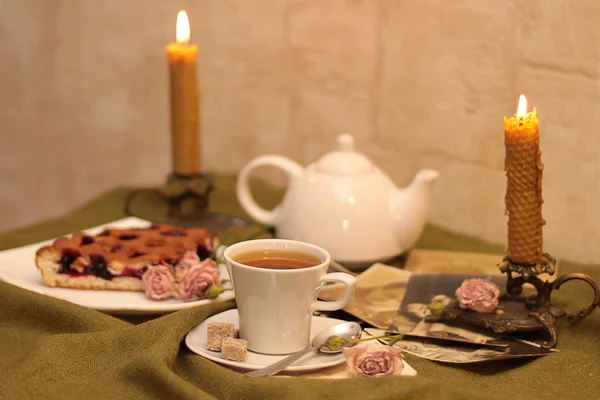 Filiżankę herbaty, kwiaty i stare fotografie — Zdjęcie stockowe
