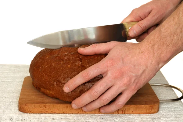 Homem cortando pão de grão a bordo — Fotografia de Stock