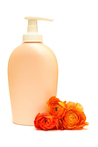 Косметическая бутылка и оранжевый цветок — стоковое фото