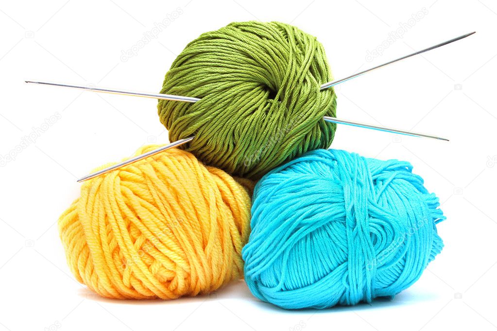 Grupo de ovillos de lana multicolores sobre un fondo de madera.