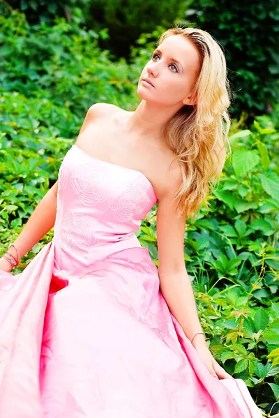 Uma jovem mulher em um vestido rosa — Fotografia de Stock
