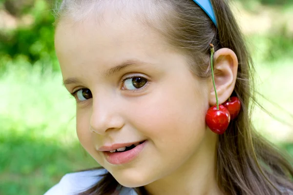 Den lilla flickan med körsbär — Stockfoto