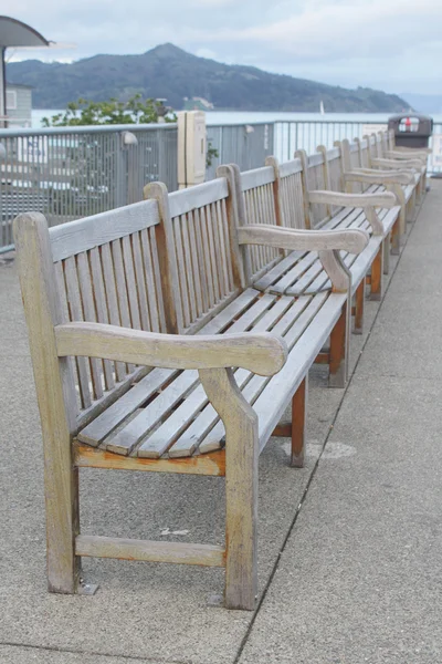 Row of wooden benches on wharf — Stock Photo, Image
