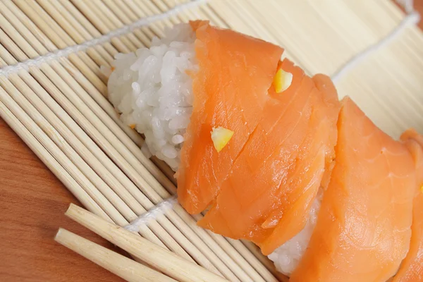 Sushi de salmón en estera de bambú —  Fotos de Stock