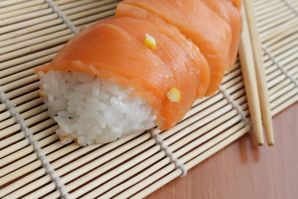 Salmon sushi on bamboo mat — Stock Photo, Image
