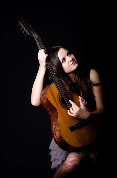Girl with a guitar on a black background — Stock Photo, Image