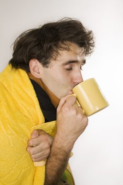 Flu. Influenzal man drinks hot tea clipart