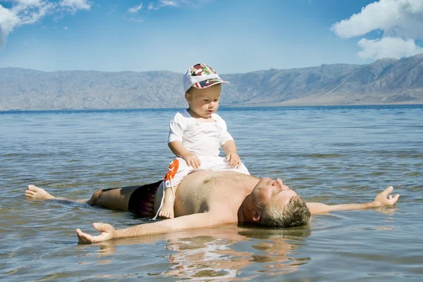 Feliz padre e hijo descansando en el agua — Foto de Stock