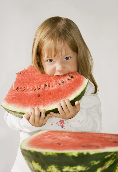 Klein meisje eet de watermeloen en — Stockfoto