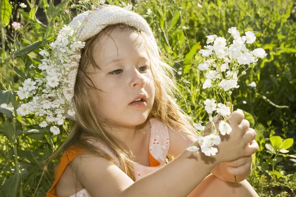 Kleine meisje bedrijf bloemen. — Stockfoto