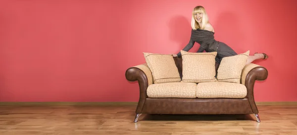 Jonge vrouw op een sofa — Stok fotoğraf