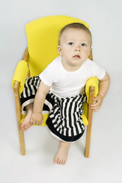 Мальчик, сидящий на стуле — стоковое фото