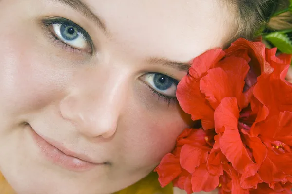 Vacker kvinna och röda hibiskus — Stockfoto