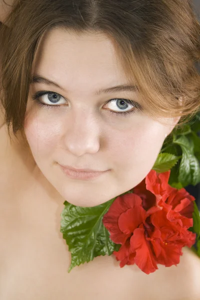 Pretty woman and red hibiscus — Stock Photo, Image