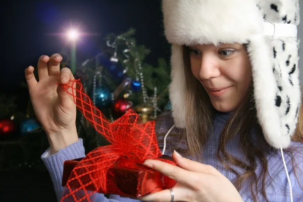 젊은 여성이 unwrapping 크리스마스 선물 — 스톡 사진