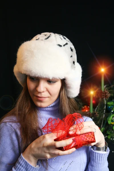 Молода жінка розгорнувши різдвяний подарунок — стокове фото