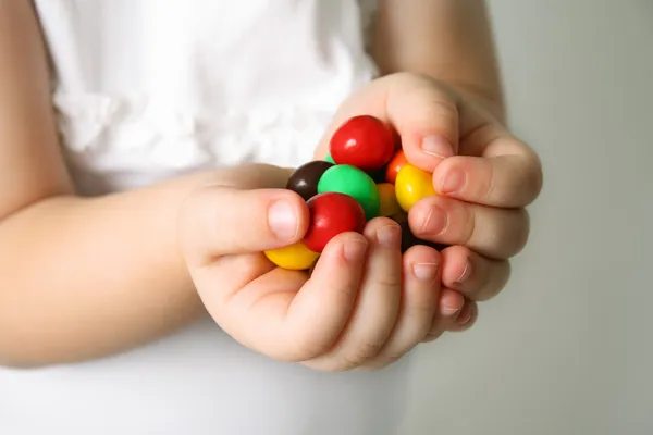 Kind die Hände die Bonbons — Stockfoto
