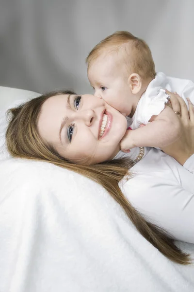 Šťastná matka s dítětem přes bílou — Stock fotografie