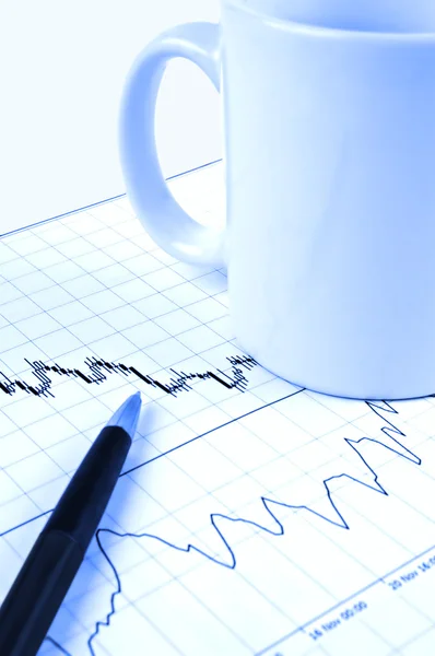 Stift und Tasse auf dem Aktienchart — Stockfoto