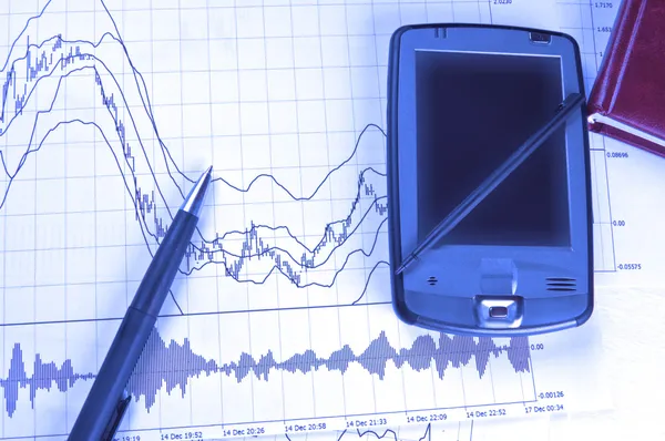 PDA och penna på börskursdiagram — Stockfoto