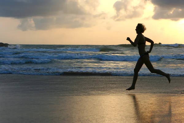 Woman runs on coast of ocean — Stock Photo, Image