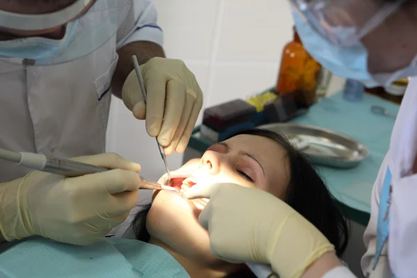 O dentista trata uns dentes instrumentos especiais — Fotografia de Stock