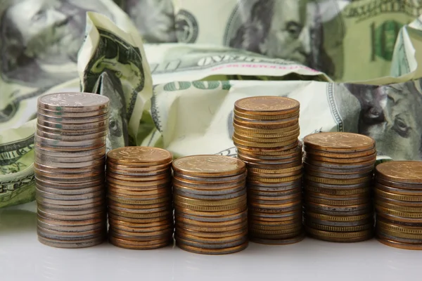Денежные доллары и куча монет — стоковое фото