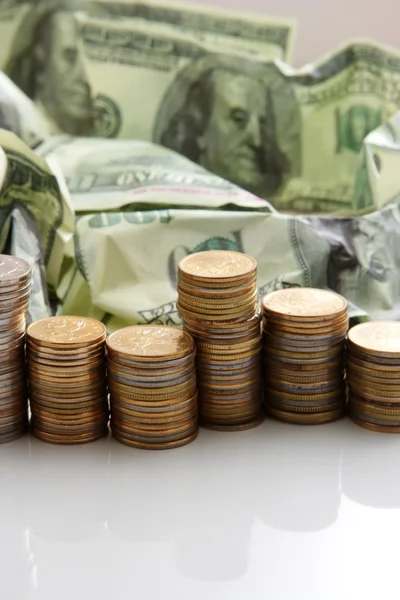 Денежные доллары и куча монет — стоковое фото