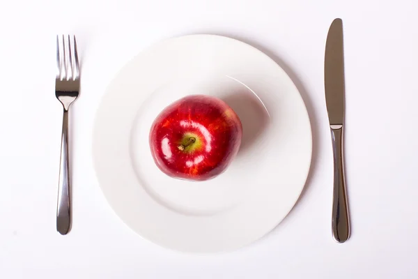 Κόκκινο μήλο σε λευκό πιάτο — Φωτογραφία Αρχείου