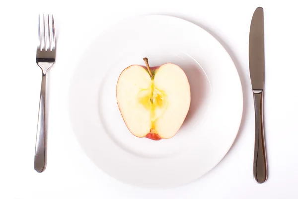Червоне яблуко на білій тарілці — стокове фото