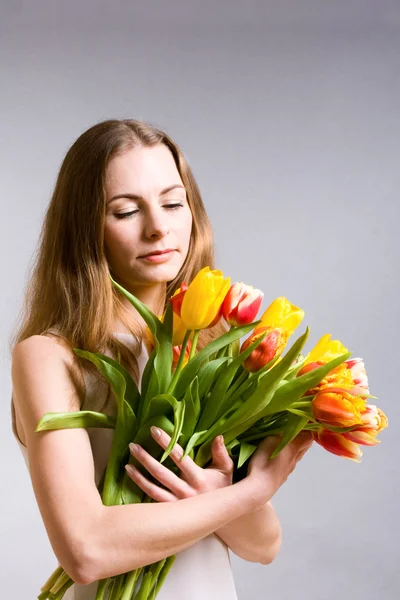 Schöne Frau mit Tulpen — Stockfoto