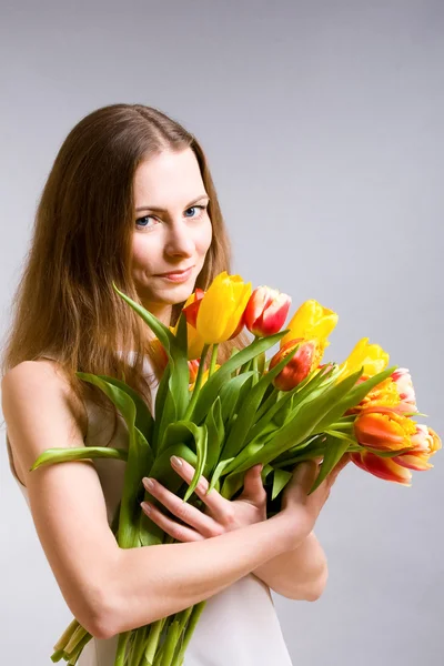 Krásná žena hospodářství tulipány — Stock fotografie