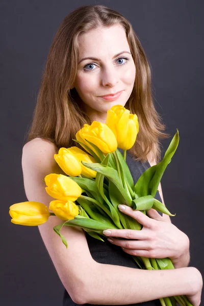 Mulher bonita segurando tulipas — Fotografia de Stock