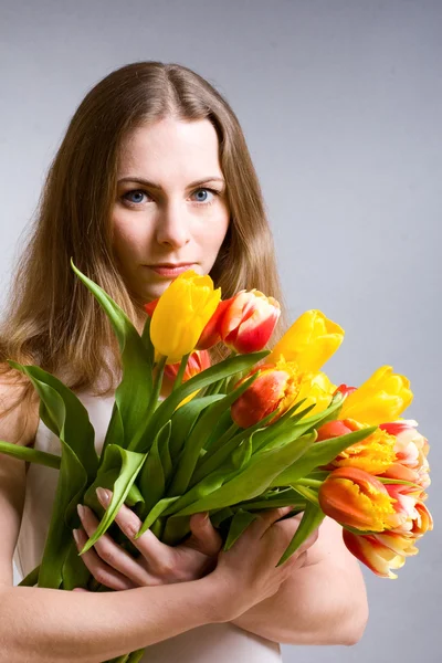 Mulher bonita segurando tulipas — Fotografia de Stock
