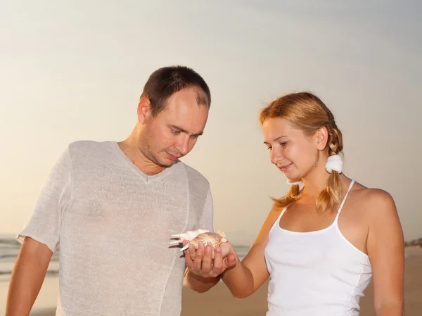 Young couple with seashell — Stock Photo, Image