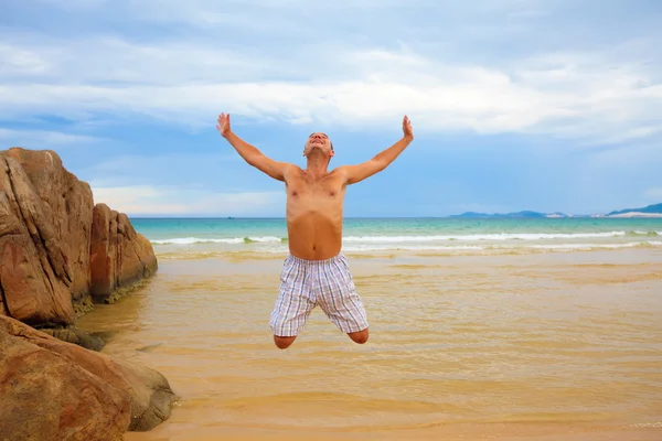 Человек, прыгающий на пляже — стоковое фото