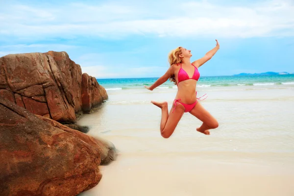 Женщина прыгает по пляжу — стоковое фото