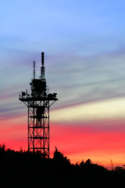 Komunikat wieży sylwetka na niebo zachód słońca — Zdjęcie stockowe