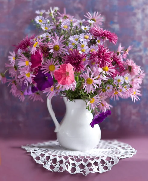 Bukett blommor i en vit kruka — Stockfoto